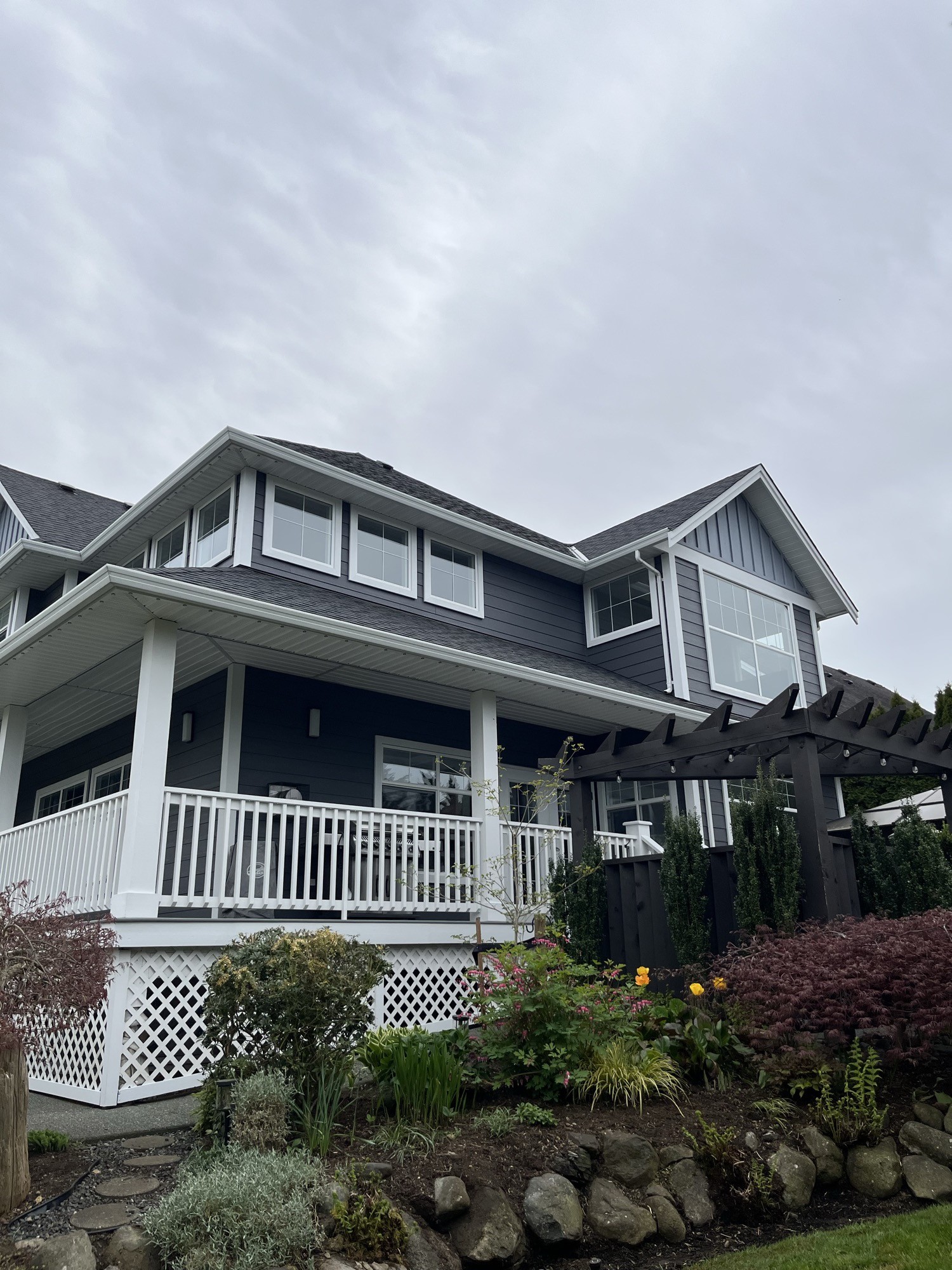 Exterior painting — covered porch with white columns and railing, pergola and spring tulips